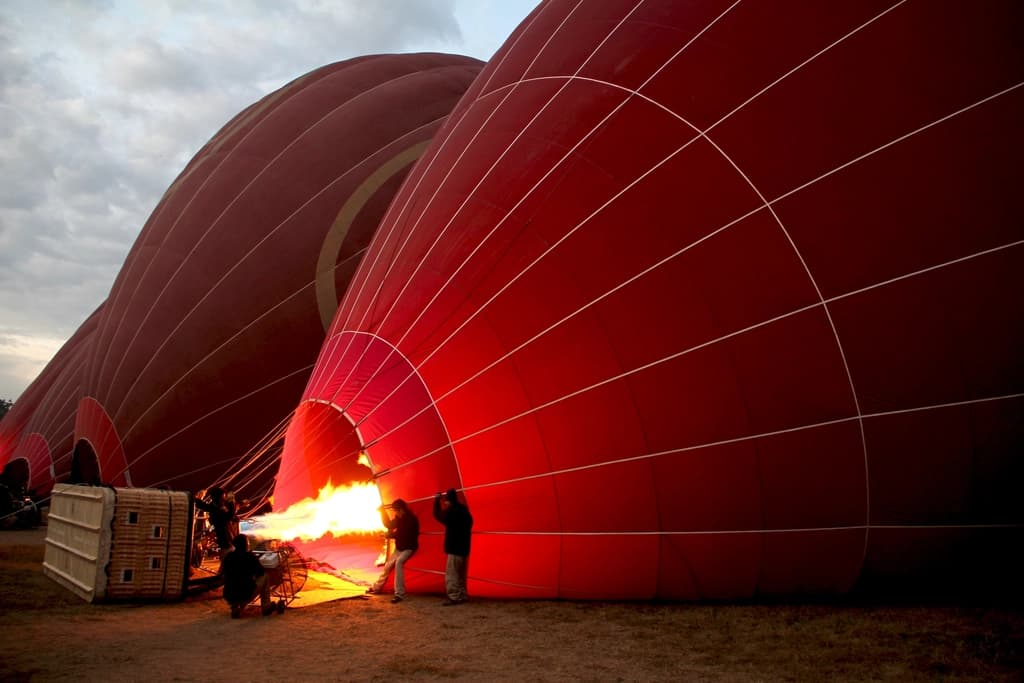 Gonflage d'une montgolfiere au petit matin, l'equipage au bruleur